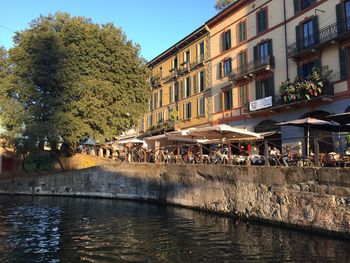 People on bridge over river in city