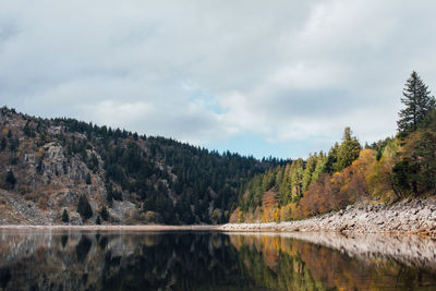 Scenic view of lake by mountain against sky