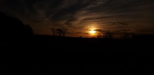 Scenic view of silhouette landscape against orange sky