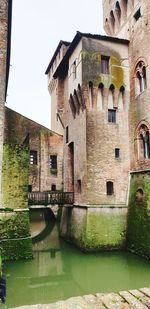 Arch bridge over canal against buildings in city