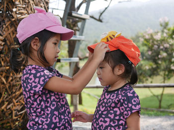 Portrait of girls wearing cap standing outdoors