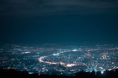 Aerial view of illuminated city against sky at night