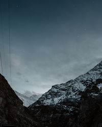 Low angle view of snowcapped mountains against sky at night