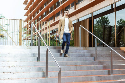 Full length of young man moving down on steps