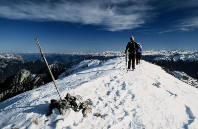 Rear view of men skiing on snowcapped mountain