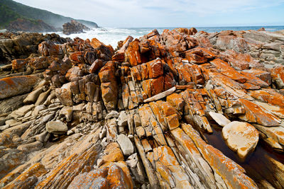 Rock formation on beach against sky