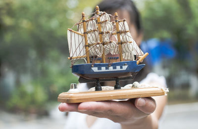 Close-up of woman holding boat toy 