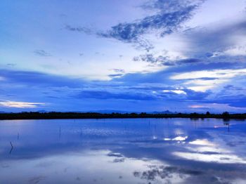 Scenic view of calm lake against cloudy sky