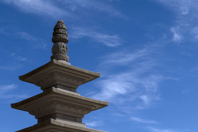 Low angle view of stone tower against blue sky