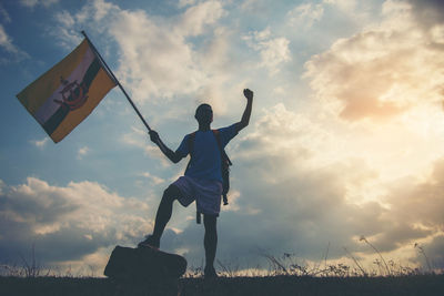 Low angle view of man standing on field against sky