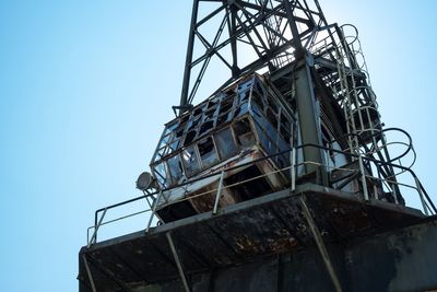 Low angle view of crane against clear blue sky