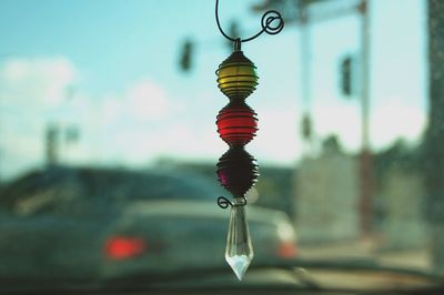 Close-up of hanging light against sky