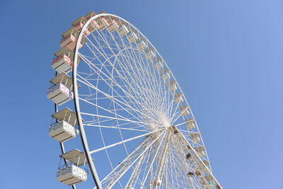 Low angle view of ferris wheel against blue sky