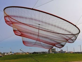 Low angle view of umbrella on field against sky