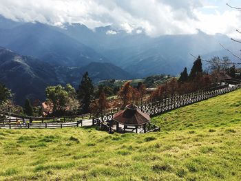 Scenic view of field by mountains against sky