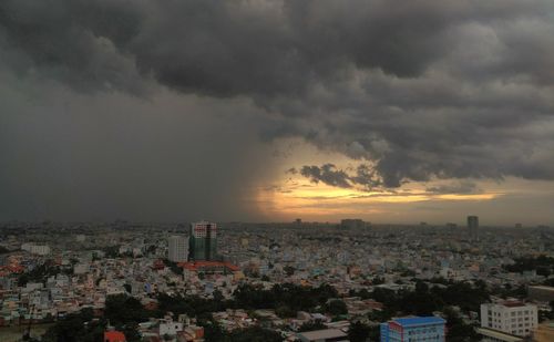 Aerial view of cityscape against storm clouds