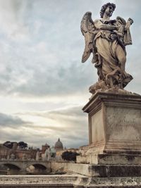 Statue of historic building against cloudy sky