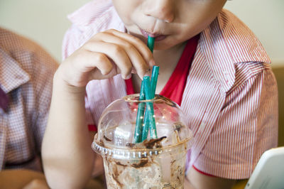 Midsection of boy drinking juice 