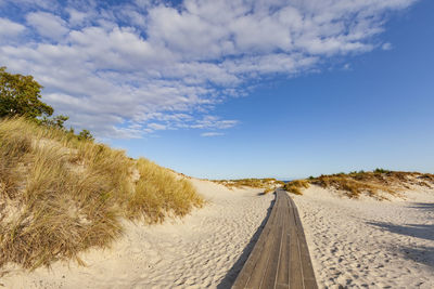 Road amidst land against sky