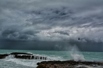 Scenic view of sea against storm clouds