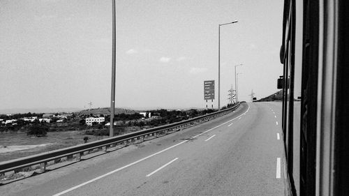 Road by city against clear sky