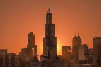 Skyscrapers in city during sunset