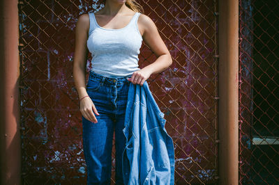 Woman standing on chainlink fence