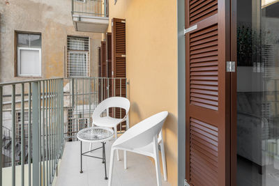 Empty chairs and tables in front of house