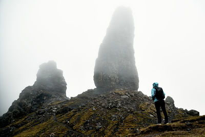 Rear view of man on rock against sky