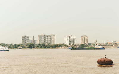 Scenic view of sea and buildings against clear sky