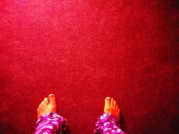 Low section of woman standing on red floor