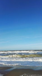 Scenic view of beach against clear blue sky