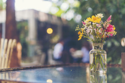 Close-up of flower vase on glass table