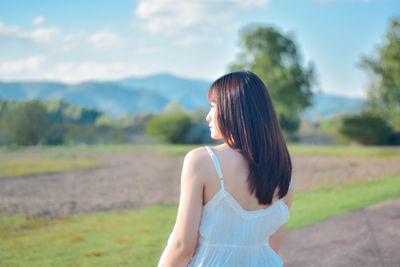 Rear view of woman standing against sky