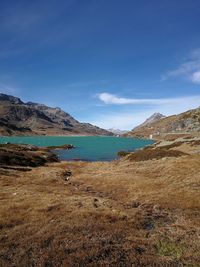Scenic view of sea and mountains against blue sky