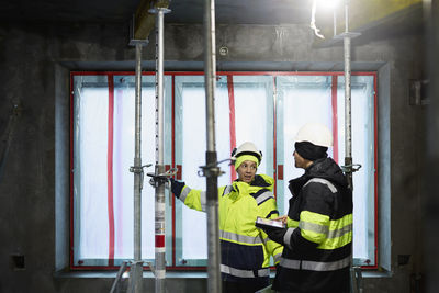 Male and female engineer working at construction site