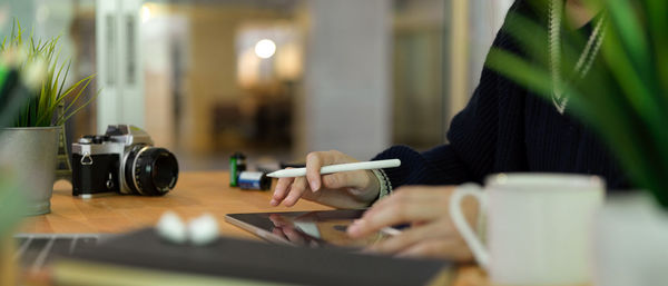 Midsection of woman using laptop at desk