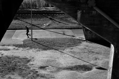 View of man jogging underneath bridge