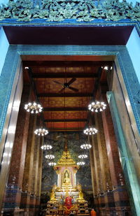 Low angle view of illuminated chandelier hanging in building