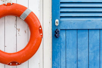 Life belt hanging on closed wooden door