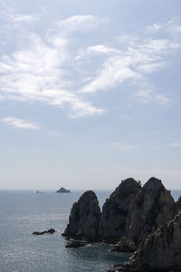 Scenic view of sea and cliff against sky