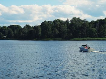 Boat sailing in river against sky