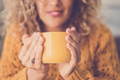 Midsection of woman holding coffee cup