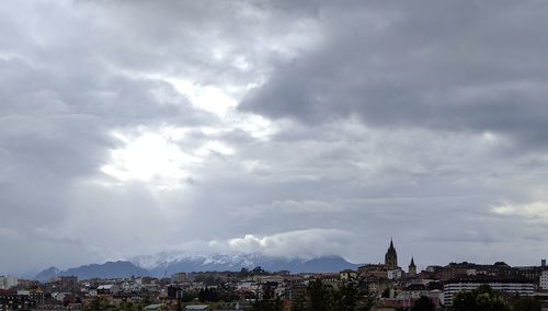 View of cityscape against cloudy sky