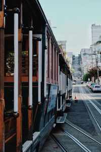 Train on railroad tracks in city against sky