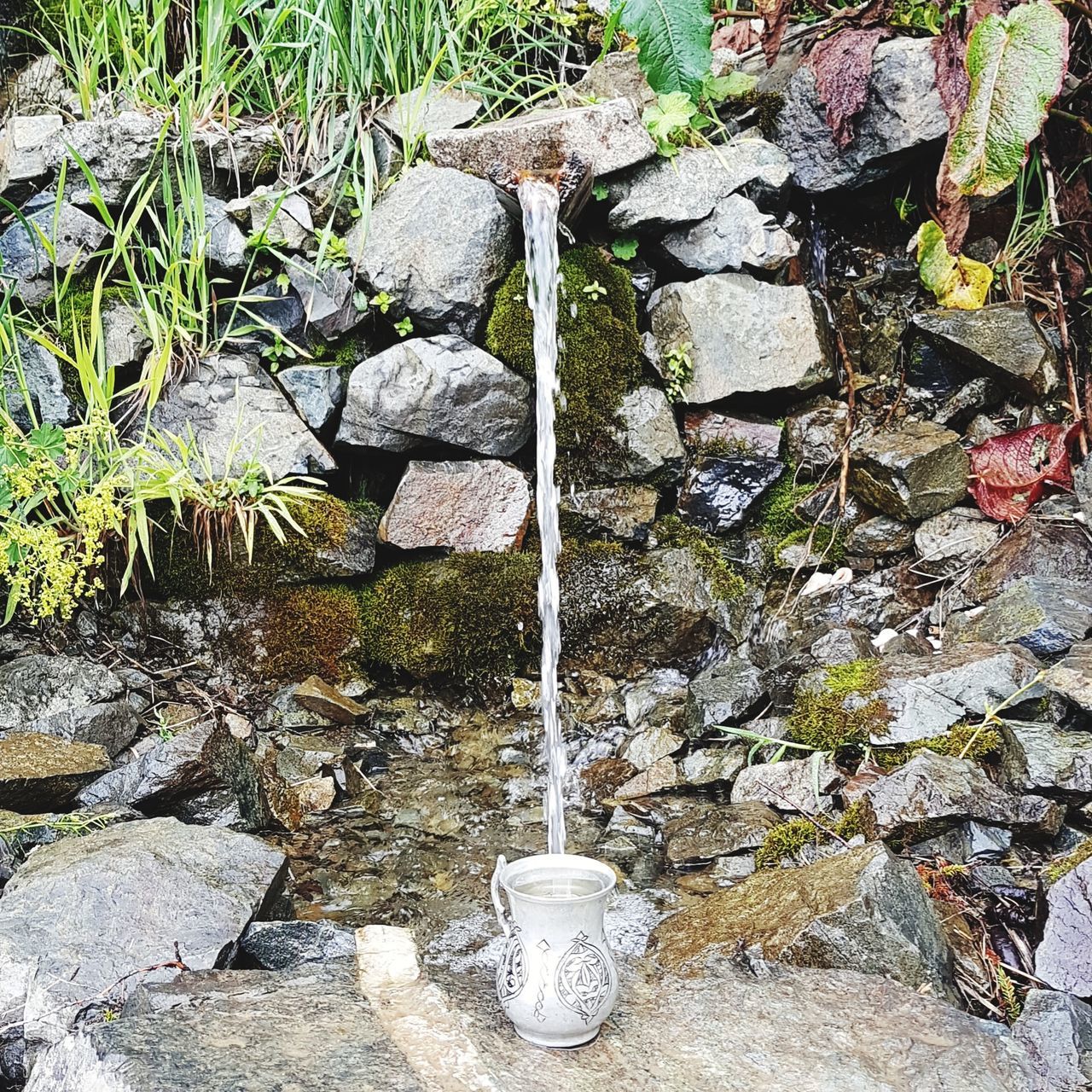 water, day, nature, rock, solid, flowing water, rock - object, no people, motion, flowing, outdoors, fountain, plant, stone - object, beauty in nature, high angle view, running water, stone wall, moss, purity