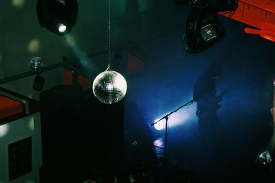 Low angle view of illuminated lighting equipment hanging on ceiling