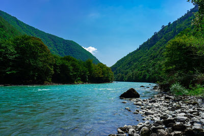 Scenic view of river amidst mountains against sky