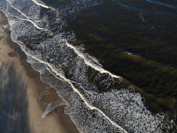 Aerial view waves crashing on coastline