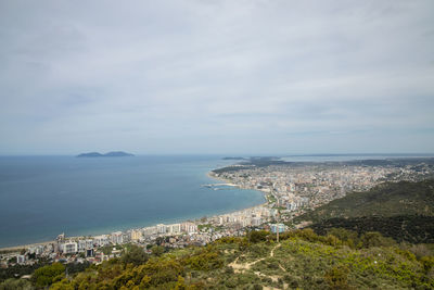 High angle view of townscape by sea against sky